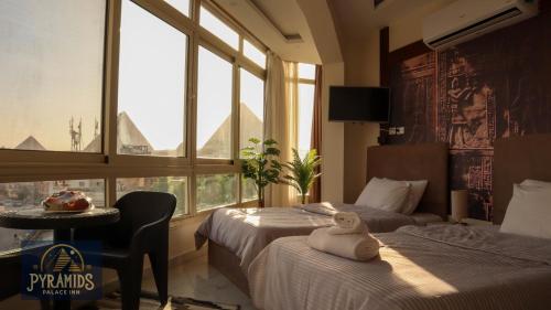 een hotelkamer met 2 bedden en een raam bij Pyramids Palace Inn in Caïro