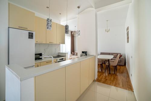 a kitchen with white cabinets and a table with chairs at The Dream Getaway & Spa by DeVasco in Becici