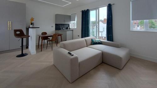 Sala de estar blanca con sofá y mesa en Luxurious London Studios en Harrow