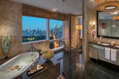 a bathroom with a tub and a view of the city at Mandarin Oriental, New York in New York