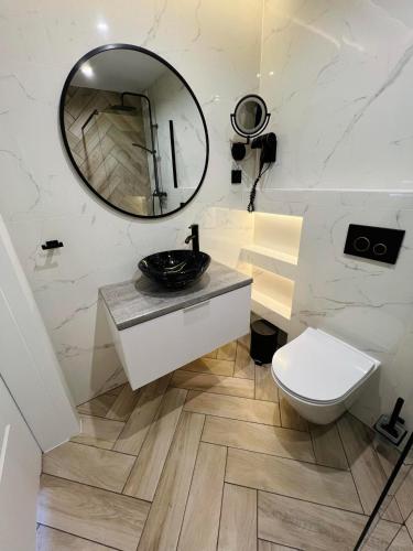a bathroom with a sink and a mirror at KarvalSea APARTAMENTY in Karwia