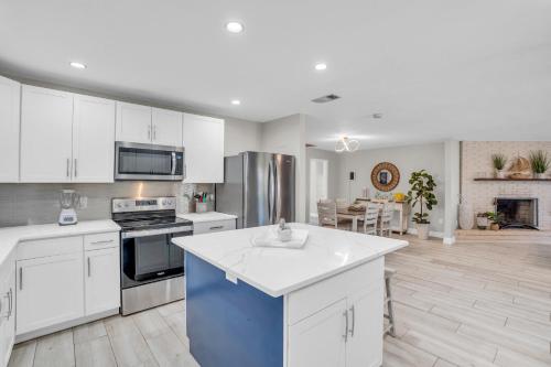 Una cocina con gabinetes blancos y un horno de estufa. en Relax Poolside & Walk or Bike to the Beach From This Amazing Naples Pool Home!, en Naples