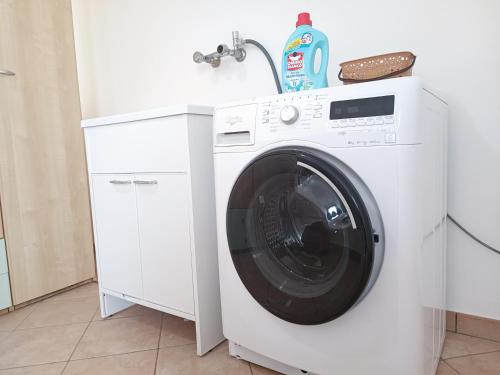 a white washing machine in a kitchen with a sink at Casa Mandorle in Ugento