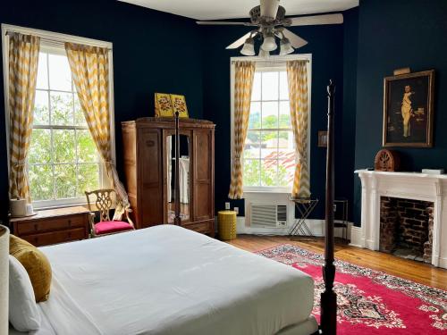 1 dormitorio con paredes azules, 1 cama y ventilador en Creole Gardens Guesthouse and Inn, en Nueva Orleans