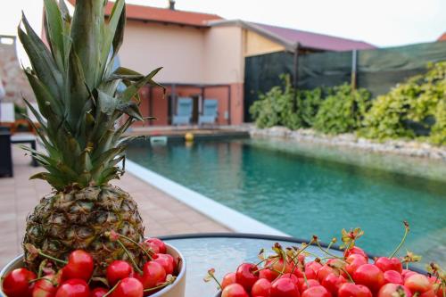 a bowl of fruit on a table next to a pool at Villa Bali - Aladinici in Stolac