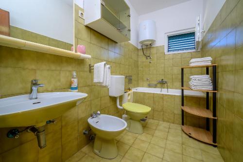 uma casa de banho com um lavatório, um WC e uma banheira em Villa Sara em Vinišće