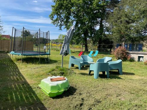 um parque infantil com cadeiras e um trampolim em LE COCOON D'ANNABELLE - JOLIE MAISON avec JEUX ET GRAND JARDIN em Pierrefitte-sur-Sauldre