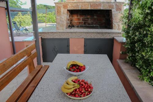 a table with two bowls of fruit on a balcony at Villa Bali - Aladinici in Stolac