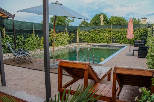a backyard with a pool with an umbrella and a table at Villa Bali - Aladinici in Stolac