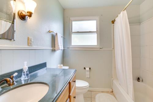 a bathroom with a sink and a toilet and a window at Centrally Located Gonzales Home with Yard! in Gonzales