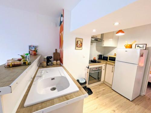 a kitchen with a sink and a refrigerator at Appartement rétro proche Disneyland et Paris in Nanteuil-lès-Meaux