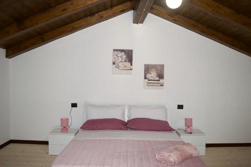 1 dormitorio con 1 cama blanca grande con almohadas rojas en IL CORTILE DELLE ZAGARE, en Pollica