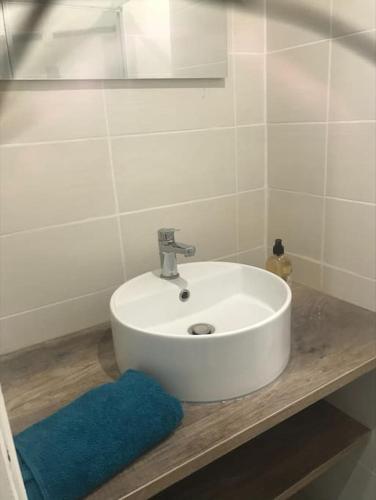 La salle de bains est pourvue d'un lavabo blanc et d'un tapis bleu. dans l'établissement Joli appart proche de la mer, à Marseille
