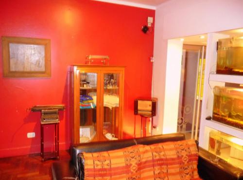 a living room with a couch and a red wall at Bohemia Hotel Boutique in Mendoza