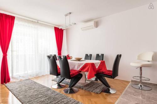 comedor con mesa roja y sillas en Apartments Nena, en Split