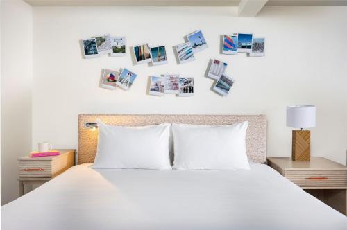 a bedroom with a white bed with pictures on the wall at Blue Water Resort in South Yarmouth