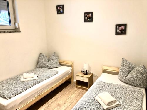two beds in a room with pictures on the wall at Vilstal Apartments in Reisbach