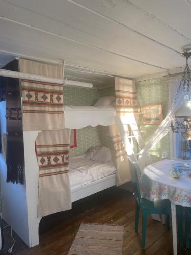 a bedroom with a bunk bed with a table at Skäret in Åkerö