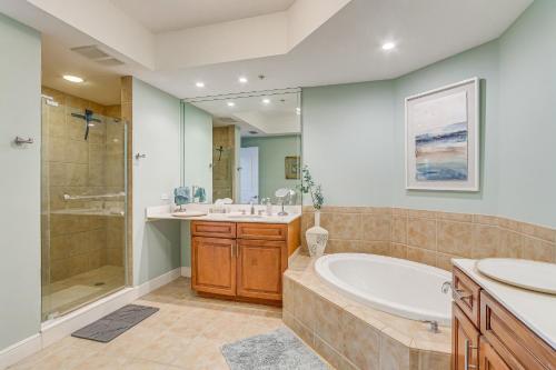 a bathroom with a tub and a sink and a shower at Perdido Key Condo with Views and Golf Club Access! in Pensacola