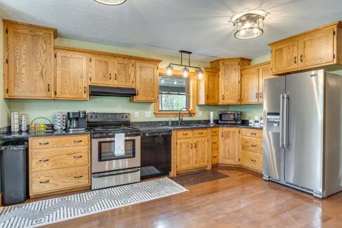 a kitchen with wooden cabinets and a stainless steel refrigerator at Family-Friendly Milton Home on 14 Acres with Hot Tub in Milton