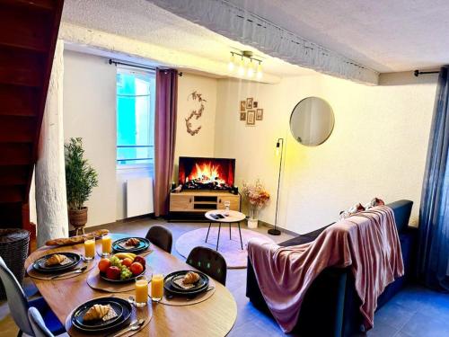 un salon avec une table et une cheminée dans l'établissement Le petit rosé, à Narbonne