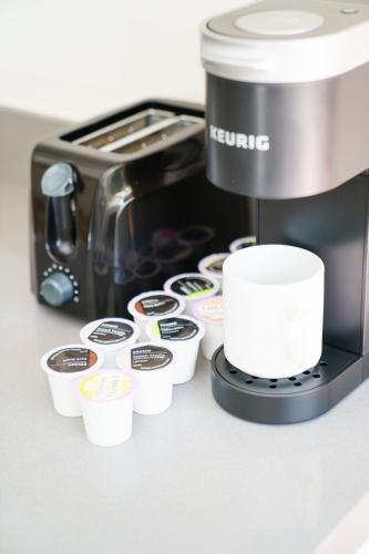 a coffee maker and cups on a counter at Franklin Suites South Beach in Miami Beach