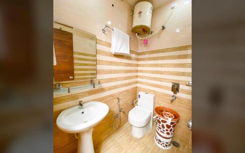 uma casa de banho com um lavatório e um WC em Hotel Golden At Delhi Airport em Nova Deli