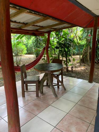 a hammock and a table and chair on a patio at Brigitte's Ranch in Cahuita