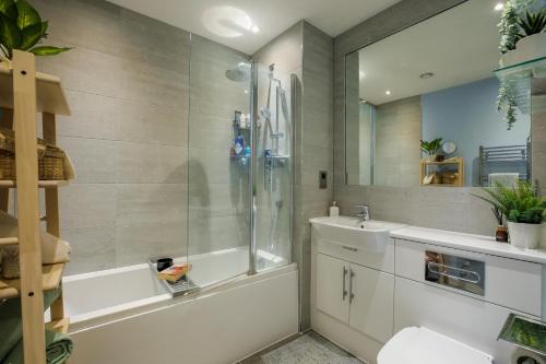 a bathroom with a tub and a sink and a shower at Amazing London City Skyline View & Transport Links in Barking