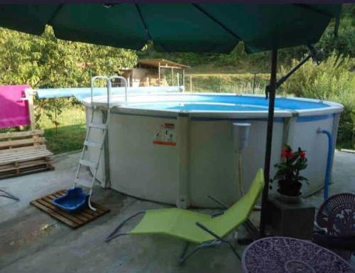 un bain à remous avec une échelle et un parasol dans l'établissement Gîte de la vallée, à Siorac-en-Périgord