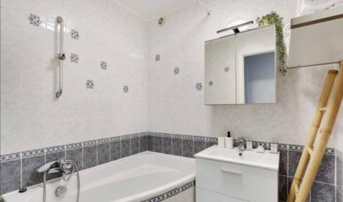 y baño con bañera y lavamanos. en Superbe appartement lumineux et calme en Saint-Ouen