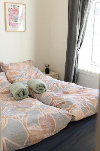 a bed with two pillows on it in a bedroom at Sentralt og romslig i Kristiansand sentrum in Kristiansand