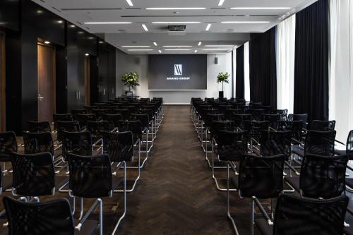 a conference room with black chairs and a screen at Hotel AMANO Grand Central in Berlin