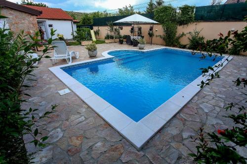 una grande piscina in un cortile con patio di Villa Bella a Mostar