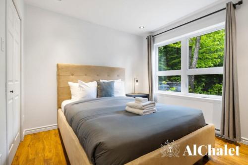 a bedroom with a large bed with a window at L'ours et le Renard- Chalet familial et Spa in Petite-Rivière-Saint-François