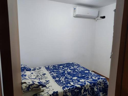 a bed in a room with a blue and white blanket at Apartamento DA PAZ perto de Jauá(4km) Villas do Atlantico(4km) in Camaçari