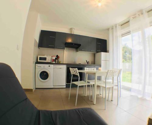 une cuisine avec une table et des chaises dans une pièce dans l'établissement Casa Bartoli, T2 Entre Mer et Montagne, à Isolaccio-di-Fiumorbo