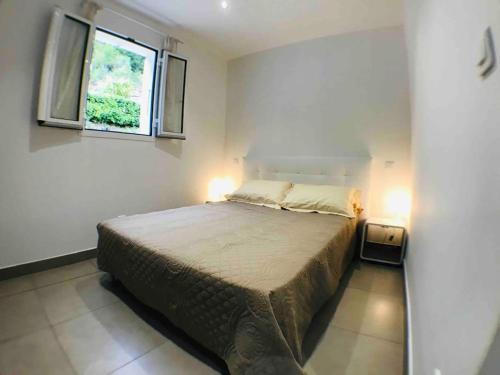 une chambre avec un lit dans une pièce avec une fenêtre dans l'établissement Casa Bartoli, T2 Entre Mer et Montagne, à Isolaccio-di-Fiumorbo