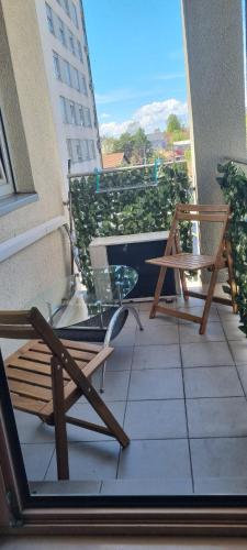 a balcony with two wooden chairs on a building at Apartman Bruna in Zagreb