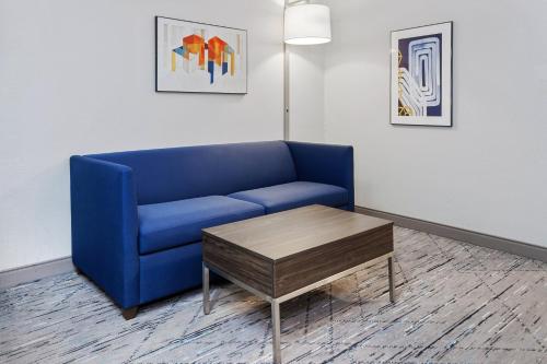 a living room with a blue couch and a coffee table at Holiday Inn Express & Suites Carmel North – Westfield by IHG in Carmel