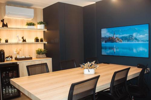 a conference room with a table and a large screen tv at Hotel San Marinho in União da Vitória