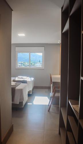 a room with two beds and a window at Hotel San Marinho in União da Vitória