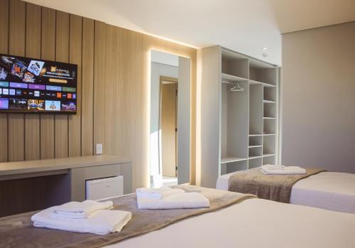 a hotel room with two beds and a tv at Hotel San Marinho in União da Vitória