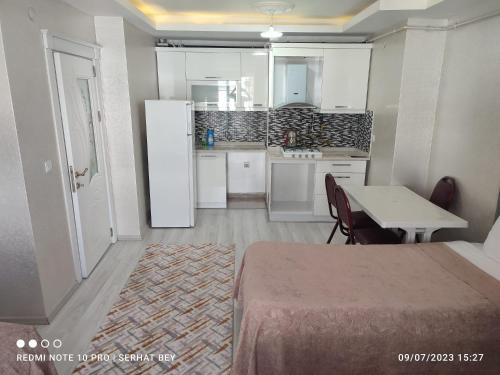 a kitchen with a table and a white refrigerator at Espinaz Apart Otel in Bostaniçi