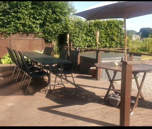 a table and chairs and an umbrella on a patio at Loch View, Lairg in Lairg