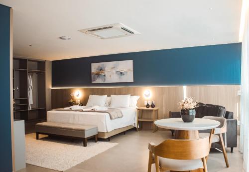 a bedroom with a bed and a table and chairs at Hotel San Marinho in União da Vitória