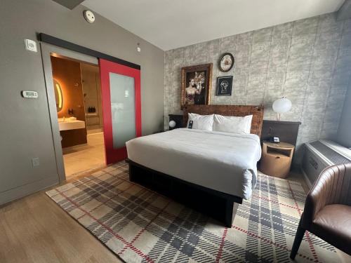 a bedroom with a large bed and a red door at Hotel Indigo Baton Rouge Downtown by IHG in Baton Rouge