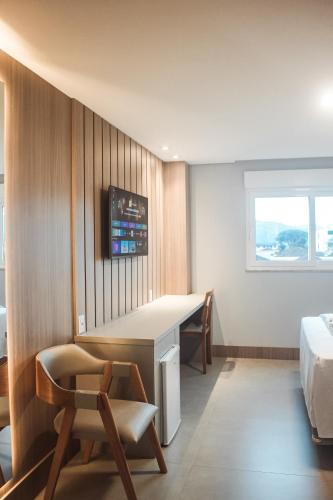 a hotel room with a desk and a bed at Hotel San Marinho in União da Vitória