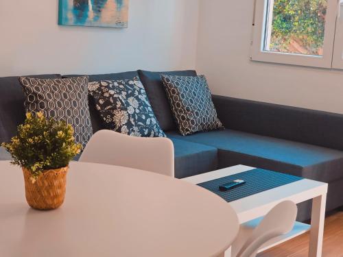 a living room with a blue couch and a table at La casita de Mercedes in Málaga
