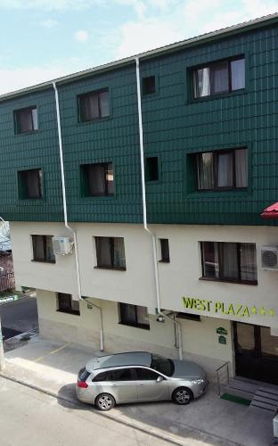 a car parked in front of a green and white building at West Plaza Residence in Bucharest